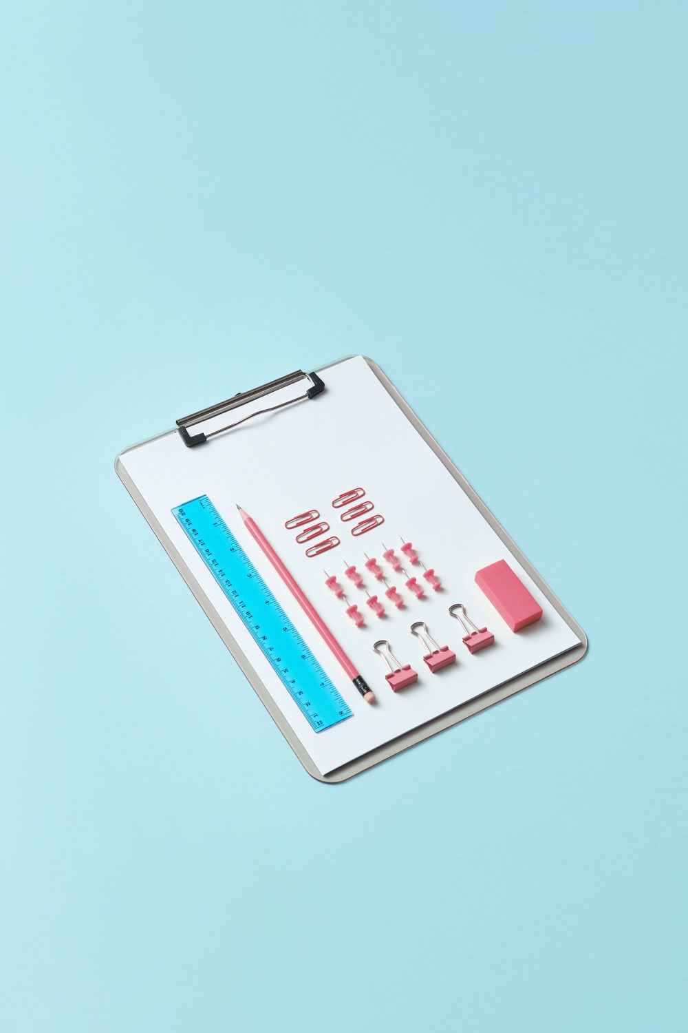 A clipboard with neatly arranged stationery